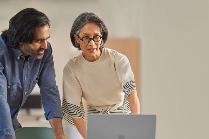 Photo of employees looking at laptop